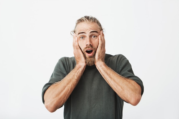 Retrato de hombre barbudo hermoso con buen peinado cogidos de la mano en la cabeza en excitemen