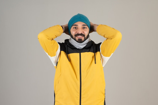 Foto gratuita retrato de hombre barbudo en ropa de abrigo de pie y posando.