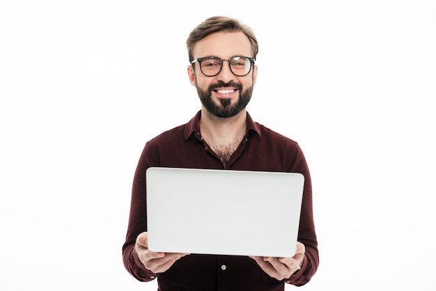 Foto gratuita retrato de un hombre barbudo sonriente con ordenador portátil