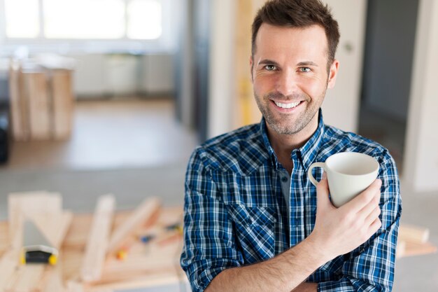 Retrato de hombre bebiendo café en el lado de la construcción