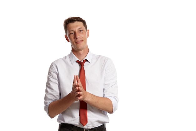 Foto gratuita retrato de un hombre brunet exitoso con ojos marrones, vestido con una camisa blanca y una corbata roja. está mirando a la cámara y posando en un estudio aislado sobre un fondo blanco. concepto de gesticulación