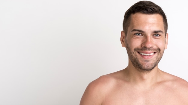 Foto gratuita retrato de hombre sin camisa feliz contra el telón de fondo blanco