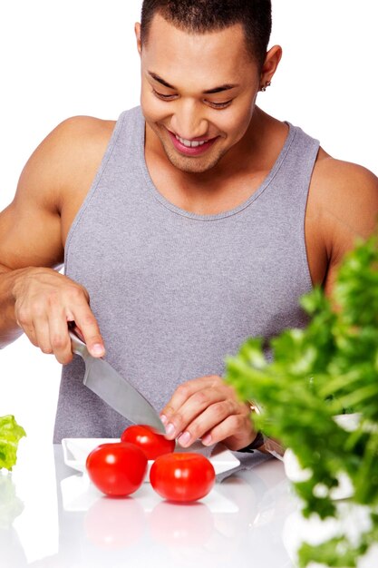 Retrato de hombre con camisa gris que va a comer tomate