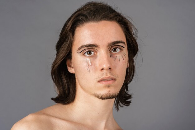 Retrato de hombre sin camisa con maquillaje
