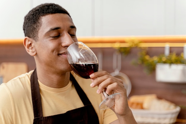 Retrato de hombre en casa bebiendo vino
