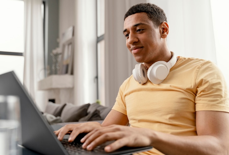 Foto gratuito retrato de hombre en casa relajante y usando laptop