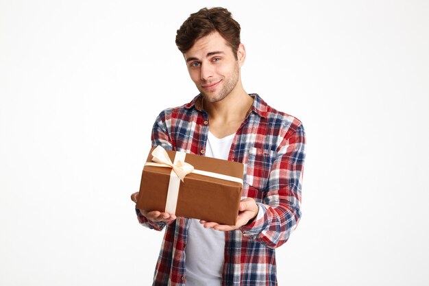 Retrato de un hombre casual atractivo sosteniendo una caja de regalo