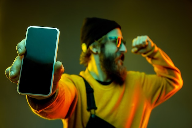 Retrato de hombre caucásico aislado sobre fondo de estudio degradado en luz de neón