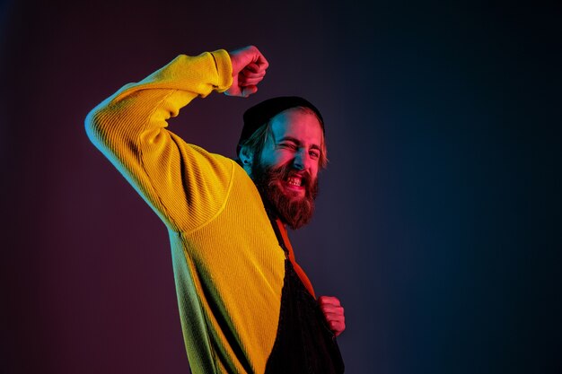 Retrato de hombre caucásico aislado sobre fondo de estudio degradado en luz de neón