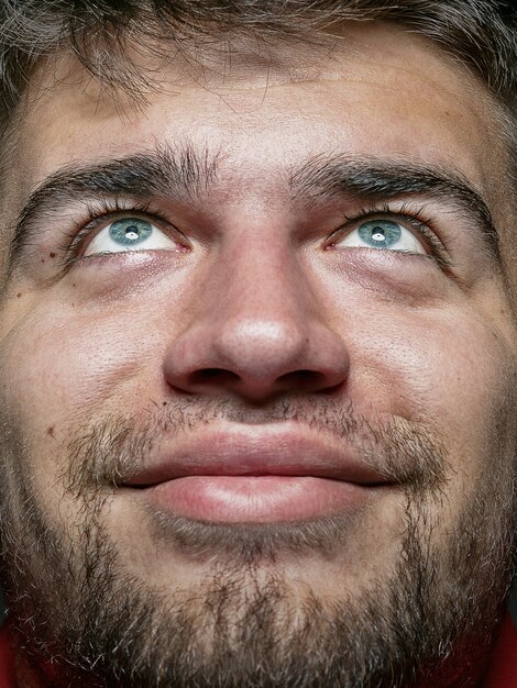 Retrato de hombre caucásico joven y emocional de cerca. modelo masculino con piel cuidada y expresión facial brillante. Concepto de emociones humanas. Sonriendo y se ve feliz.