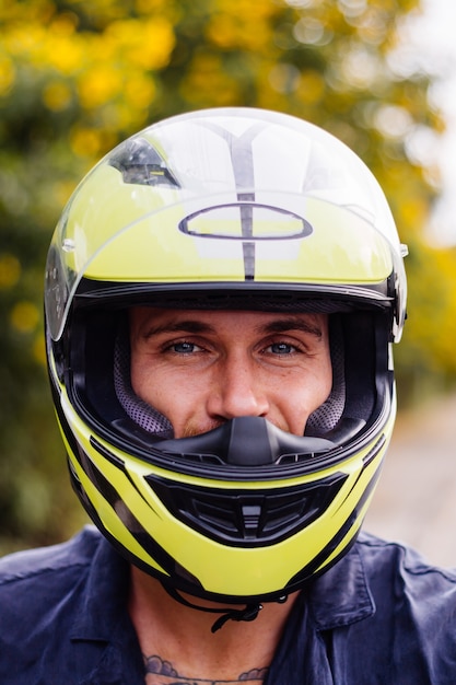 Foto gratuita retrato de hombre ciclista en casco amarillo en moto al lado de una carretera muy transitada en tailandia