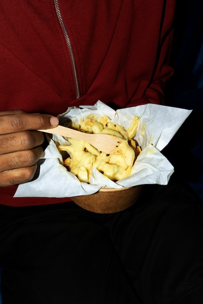 Foto gratuita retrato de hombre comiendo un delicioso plato de poutine