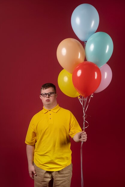 Retrato de hombre discapacitado con globos