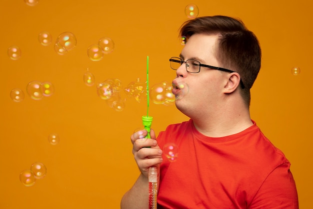 Foto gratuita retrato de hombre discapacitado con pompas de jabón