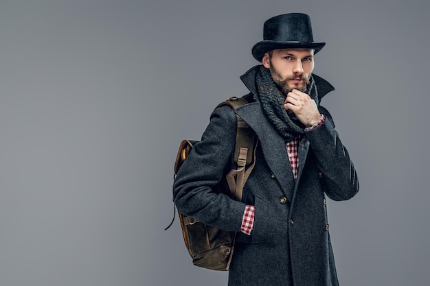 Foto gratuita retrato de un hombre elegante vestido con una chaqueta gris y un sombrero cilíndrico aislado de fondo gris.