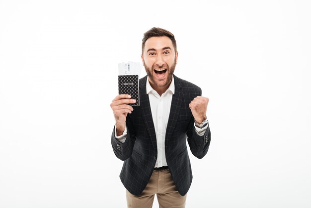 Retrato de un hombre emocionado alegre con pasaporte