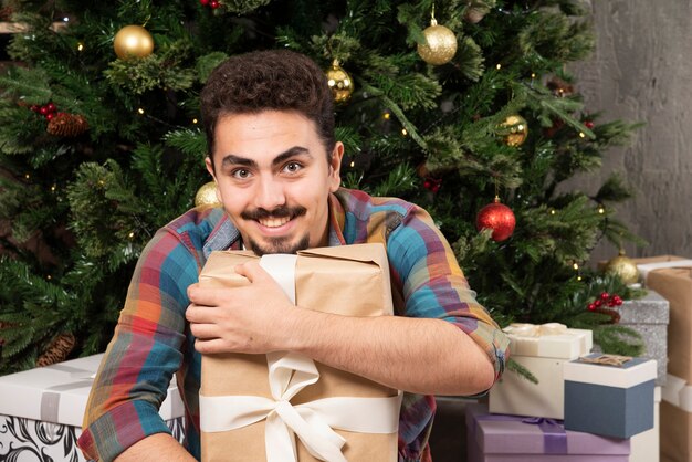 Retrato de hombre emocional feliz con caja de regalo.