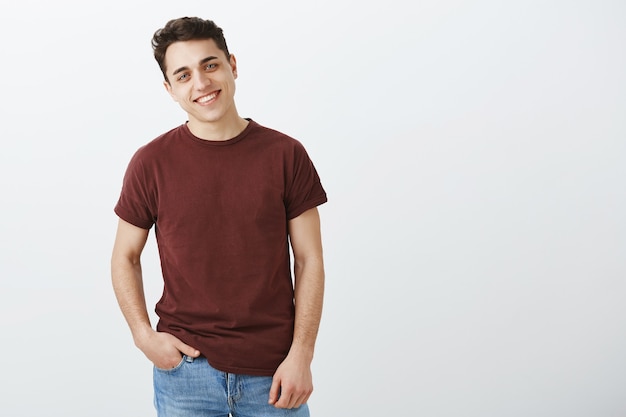 Retrato de hombre encantador de aspecto amistoso en camiseta roja