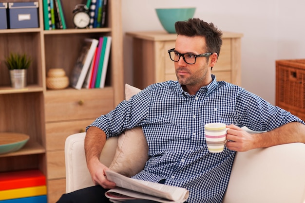 Retrato de hombre de enfoque con periódico y taza de café