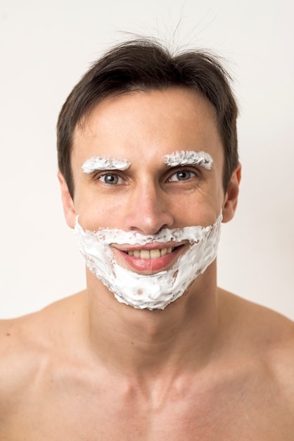 Foto gratuita retrato de un hombre con espuma de afeitar en la cara