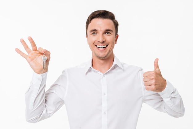 Retrato de un hombre feliz en camisa blanca con llaves