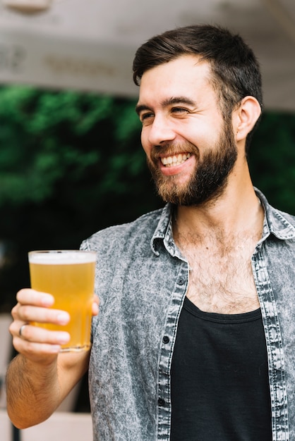 Retrato de un hombre feliz disfrutando el vaso de cerveza