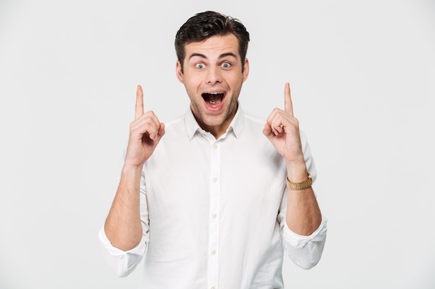 Retrato de un hombre feliz emocionado en camisa blanca