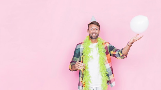 Retrato de un hombre feliz con globo blanco sobre fondo rosa