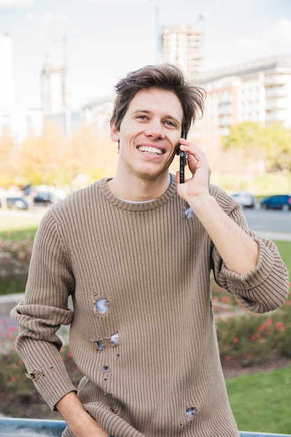 Foto gratuita retrato de un hombre feliz hablando por teléfono móvil