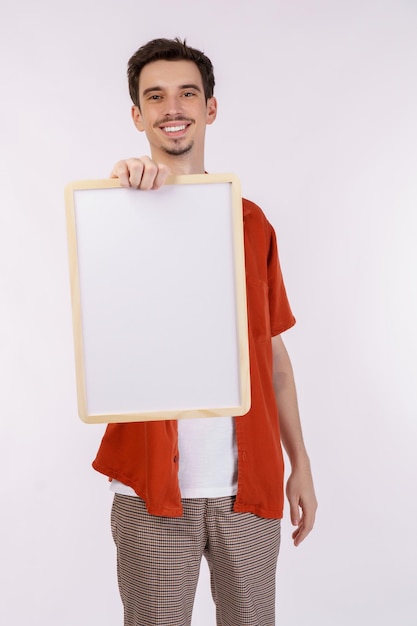 Retrato de hombre feliz mostrando letrero en blanco sobre fondo blanco aislado