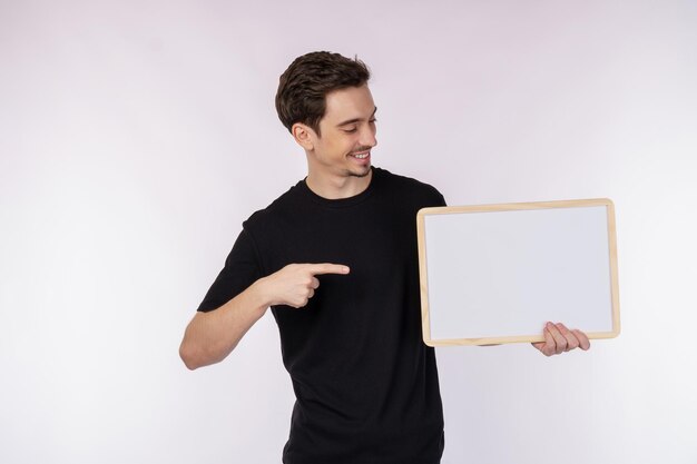 Retrato de hombre feliz mostrando letrero en blanco sobre fondo blanco aislado