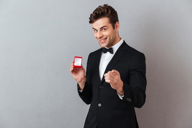 Retrato de un hombre feliz satisfecho vestido con esmoquin