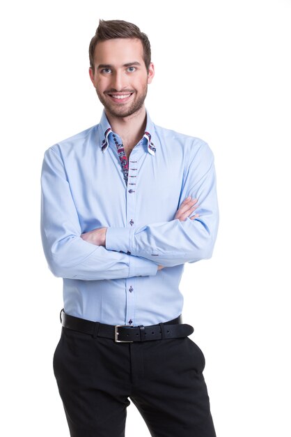 Retrato de hombre feliz sonriente con camisa azul y pantalón negro con brazos cruzados - aislado en blanco