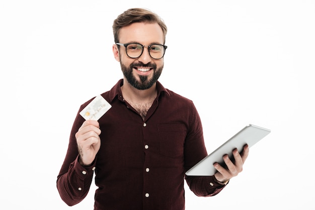 Foto gratuita retrato de un hombre feliz sonriente que sostiene la tableta. comprar en linea