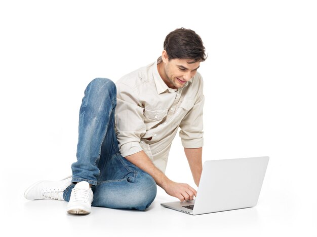 Retrato de hombre feliz trabajando en equipo portátil en casual aislado en blanco. Comunicación conceptual.