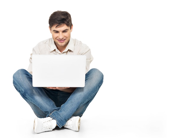 Retrato de hombre feliz trabajando en equipo portátil mirando en la pantalla aislada en blanco.