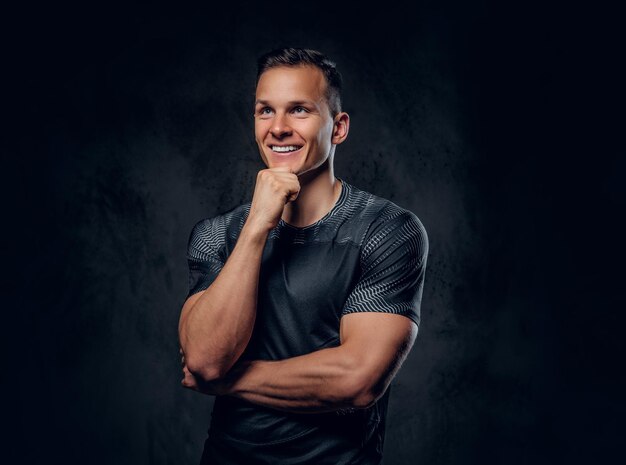 Retrato de un hombre de fitness atlético vestido con ropa deportiva sobre fondo de viñeta gris.