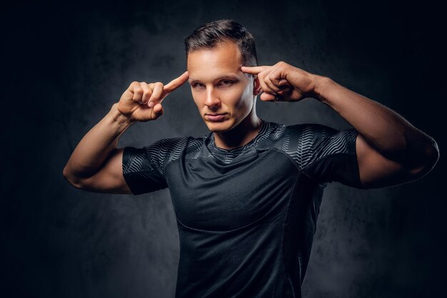 Retrato de un hombre de fitness atlético vestido con ropa deportiva sobre fondo de viñeta gris.