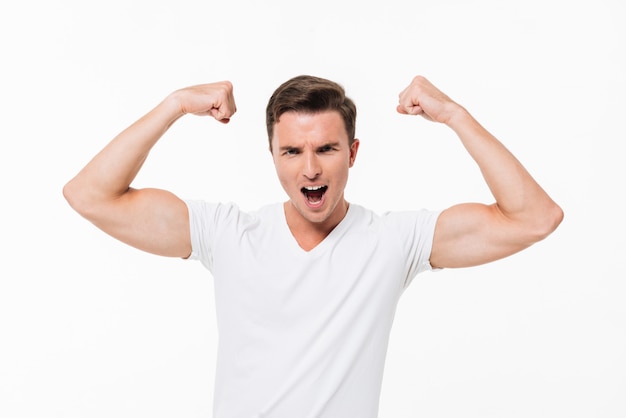 Foto gratuita retrato de un hombre fuerte y guapo flexionando sus bíceps