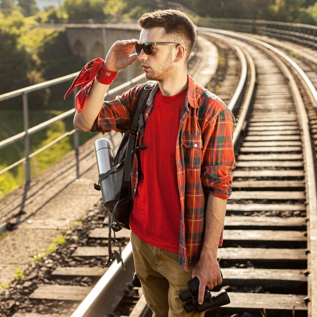 Retrato hombre con gafas de sol en el puente con binoculares