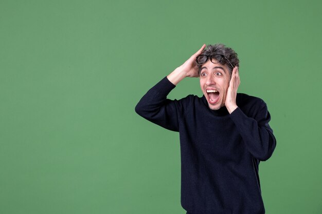 Retrato de hombre genio en foto de estudio apuntando a distancia conmocionado sobre la superficie verde color escolar macho horizontal