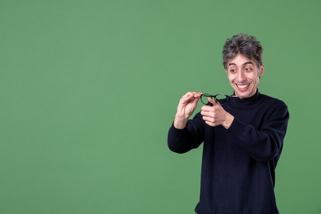 Retrato de hombre genio en foto de estudio sonriendo en la superficie verde color escolar horizontal macho