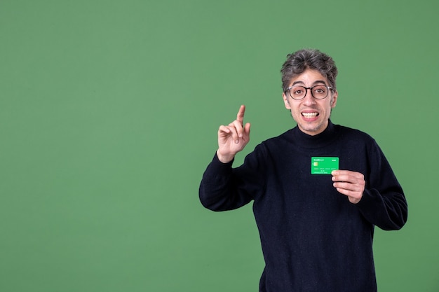 Retrato de hombre genio con tarjeta de crédito en foto de estudio pared verde