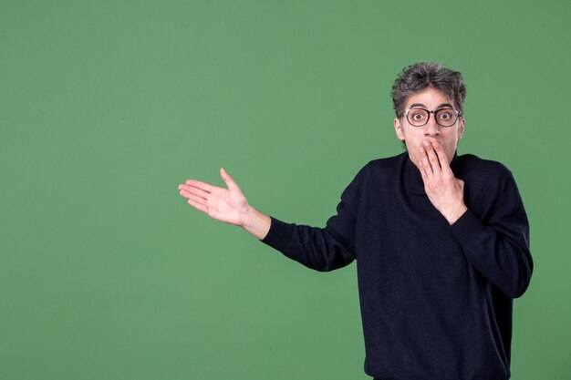 Retrato de hombre genio vestido casualmente en foto de estudio en la pared verde