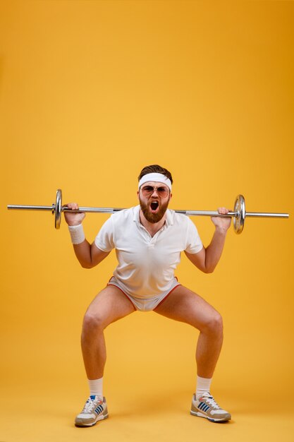 Retrato de un hombre de gimnasio haciendo ejercicios con barra pesada