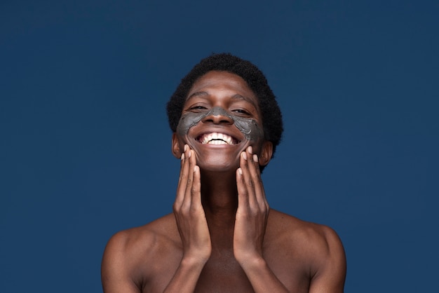 Retrato de un hombre guapo aplicando mascarilla de carbón