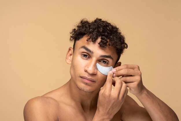 Retrato de un hombre guapo aplicando un parche en el ojo