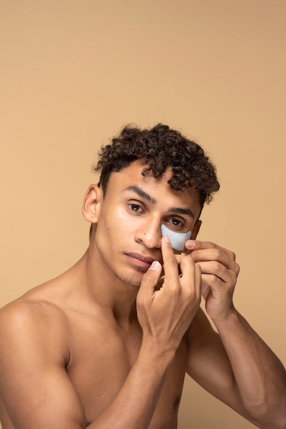 Retrato de un hombre guapo aplicando un parche en el ojo