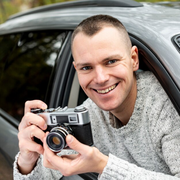 Retrato de hombre guapo con una cámara vintage