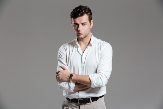 Retrato de un hombre guapo centrado en camisa blanca posando